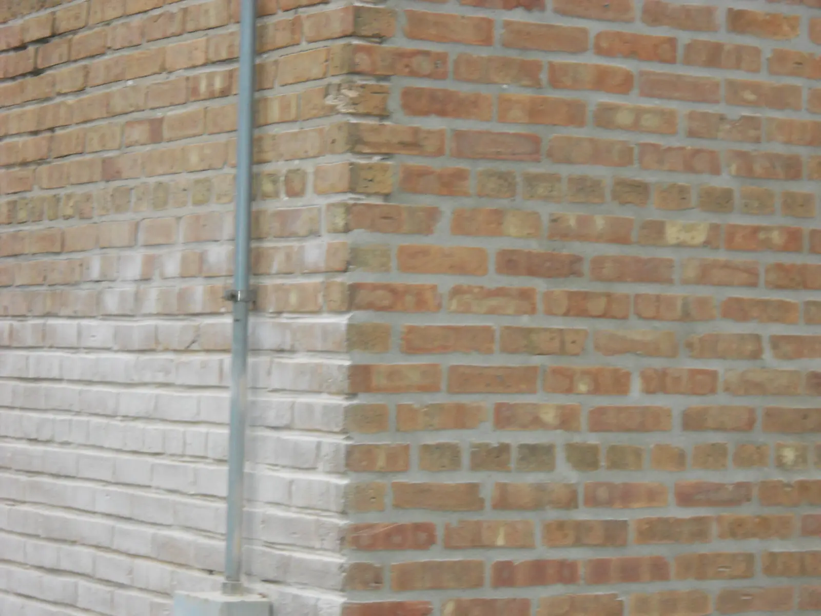 Close-up of brick wall mortar joints being repointed
