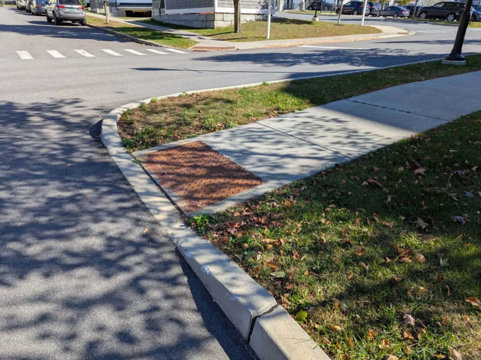 Concrete curb ramp with a detectable-warning pad at a street corner