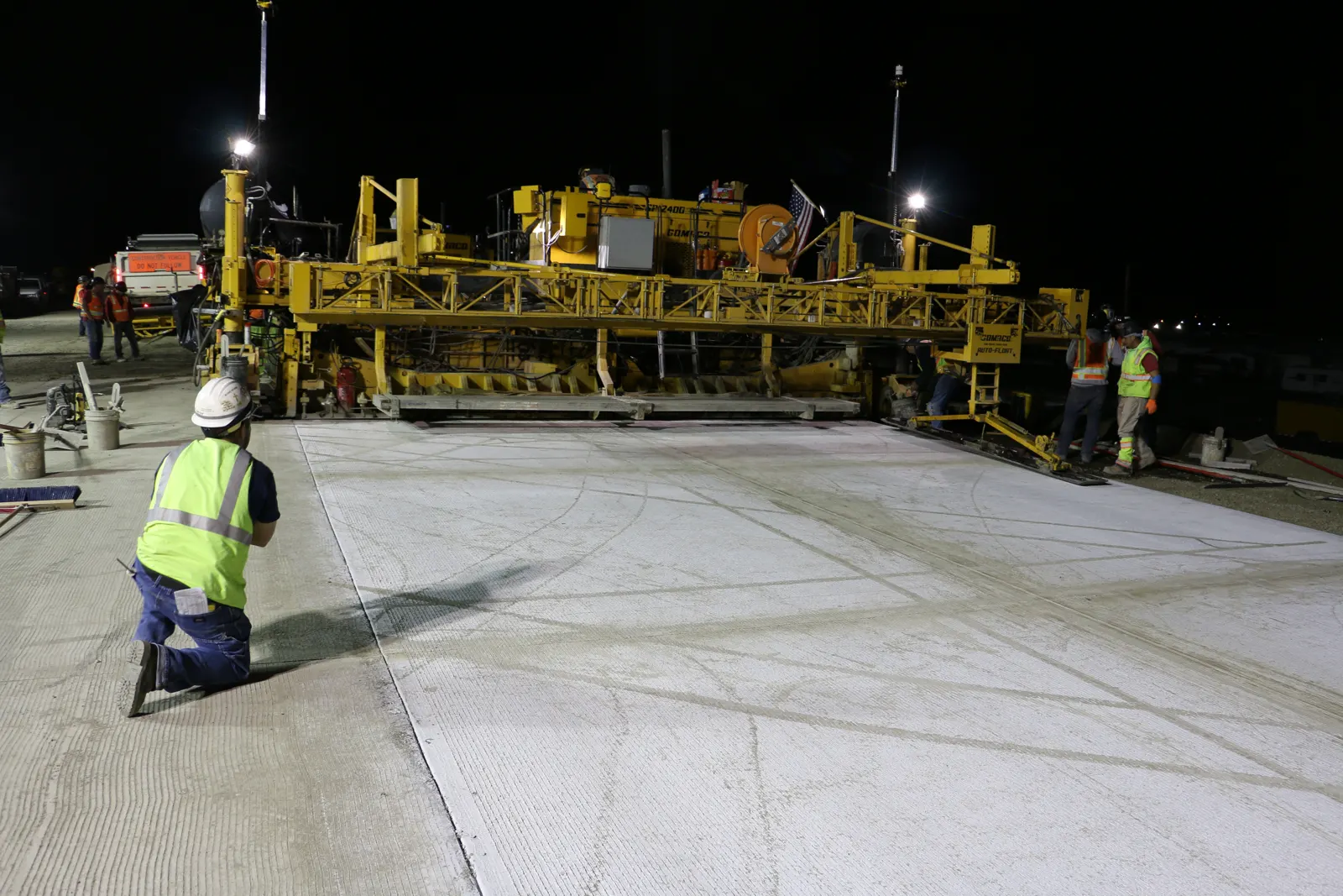 Commercial concrete paving crew finishing a large slab