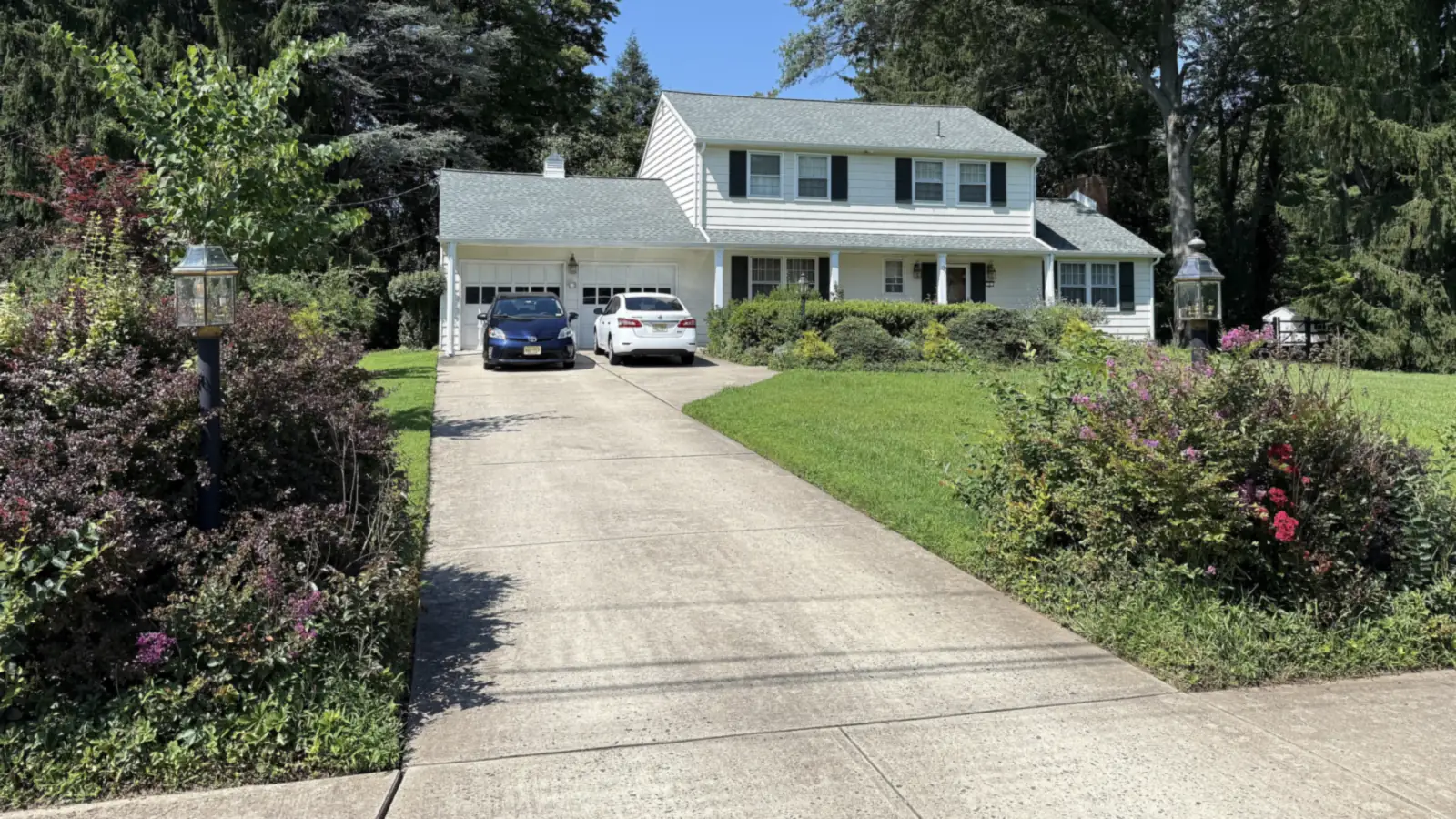 Finished concrete driveway leading up to a home garage