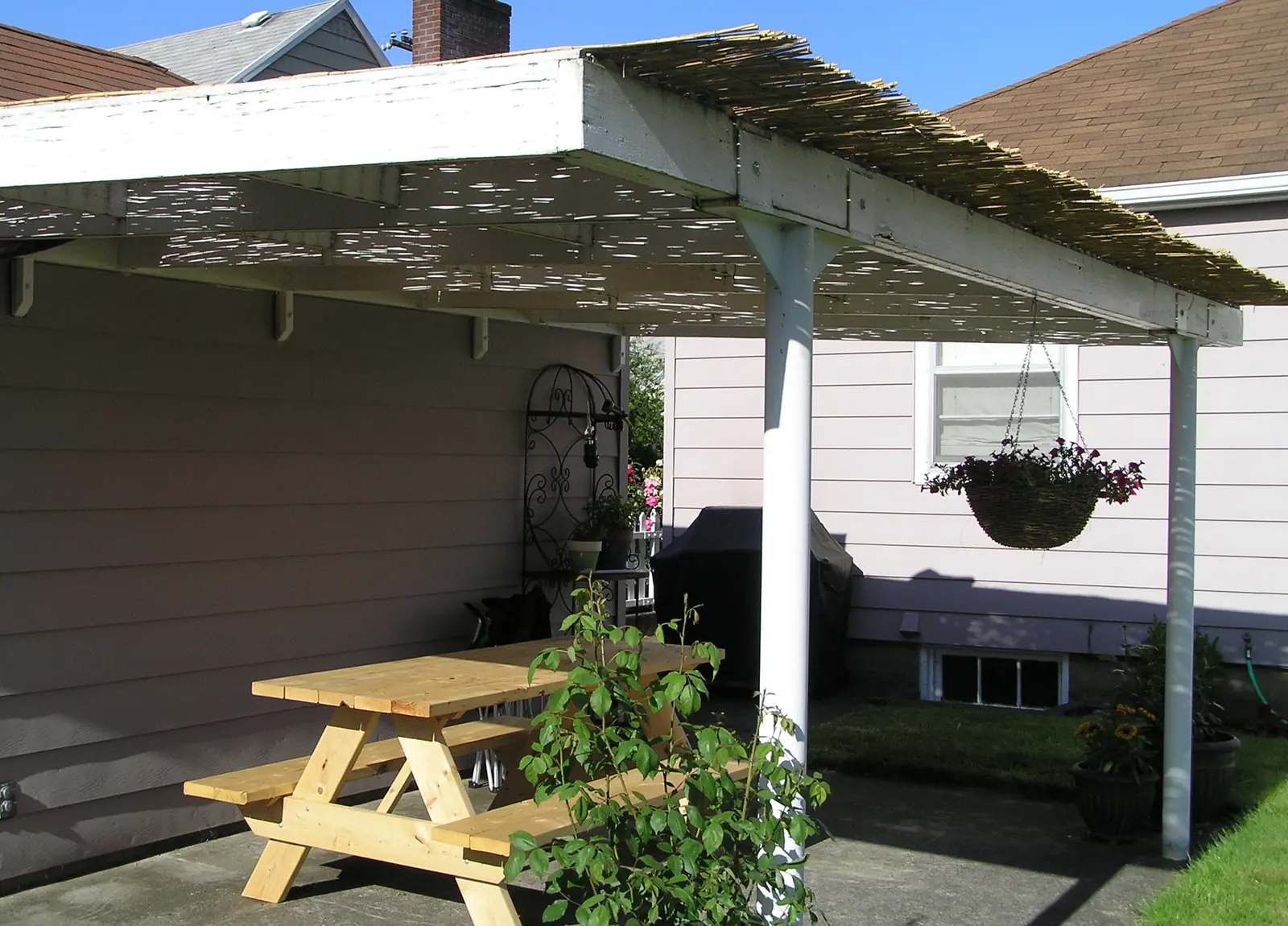Covered backyard concrete patio with a picnic table
