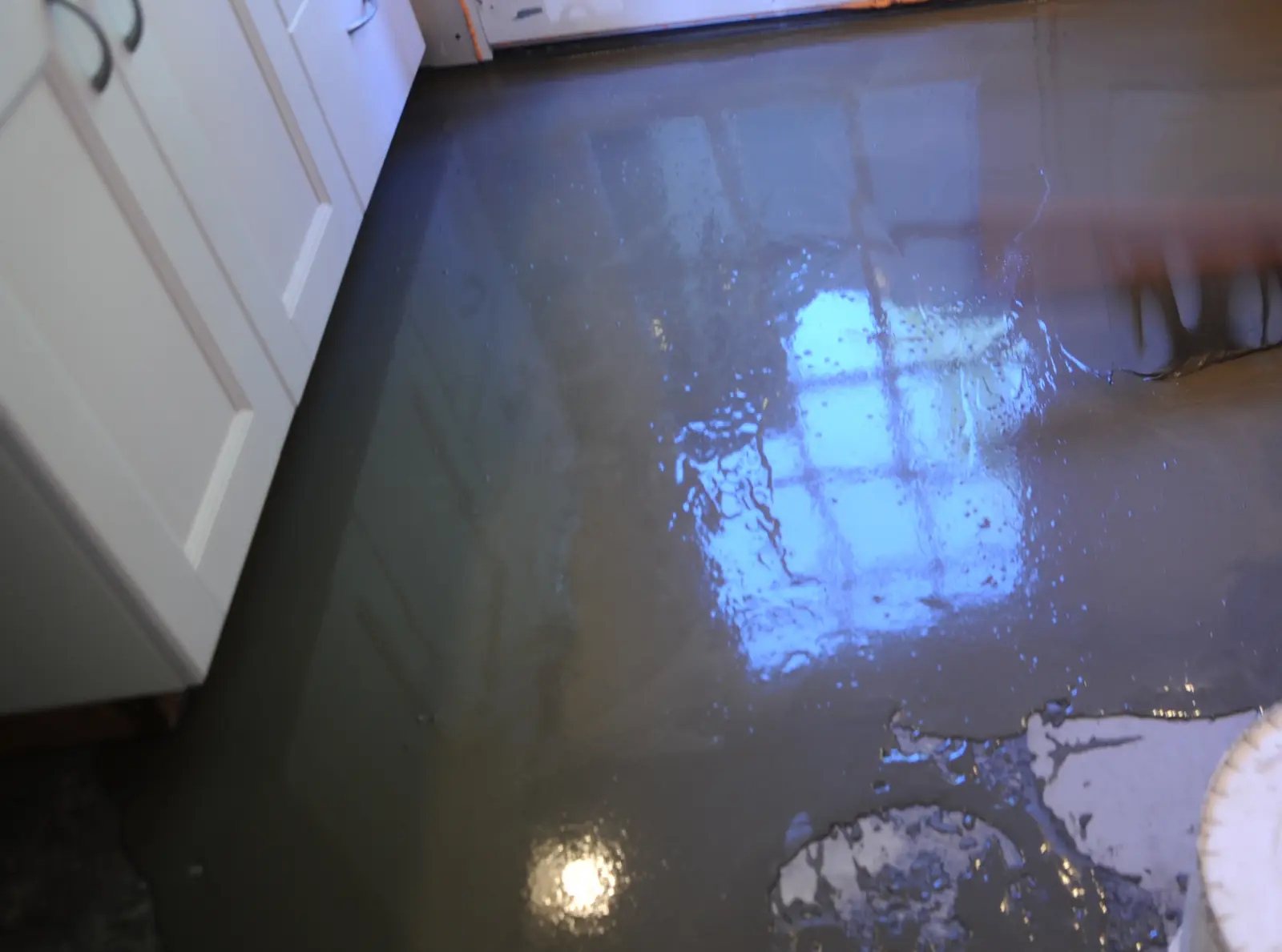 Fresh self-leveling cement overlay spread over an existing floor slab