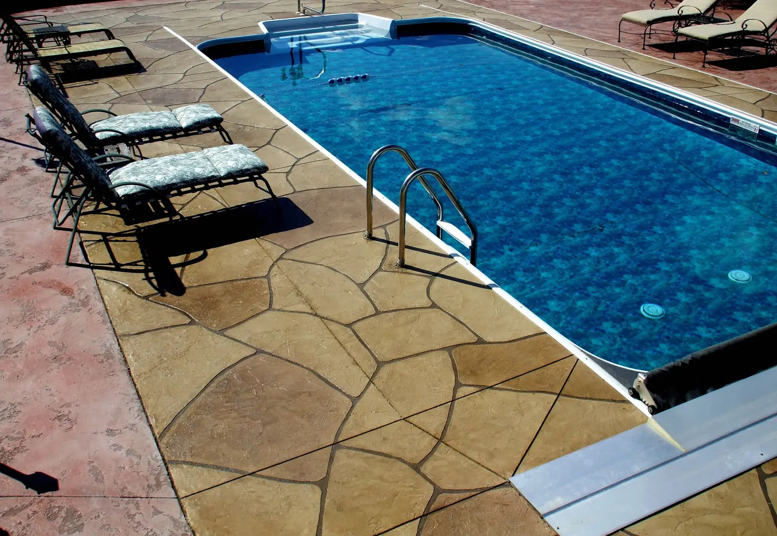Tan stamped concrete pool deck with a flagstone pattern